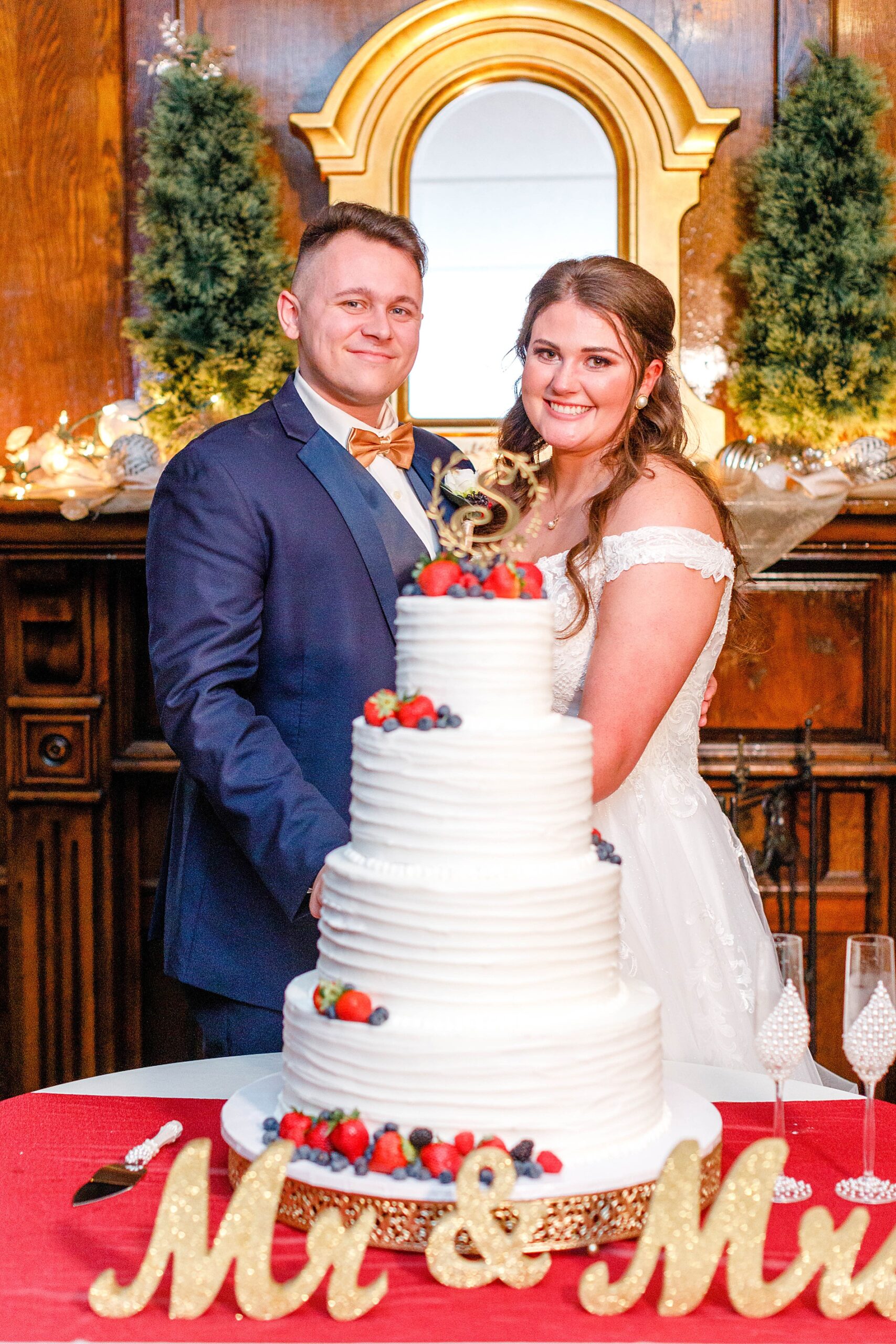 newlyweds by wedding cake